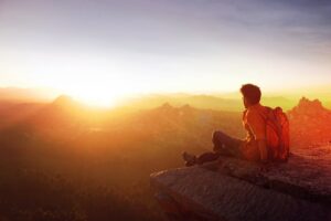 Man on mountain top at sunrise, Denver, showing EMDR therapy's transformation.