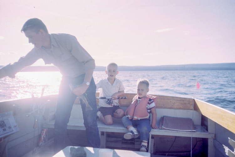 man on boat with children signifying work life balance