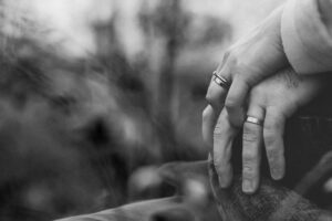 Closeup of couple's hands depicting addiction impact on relationships needing therapy.