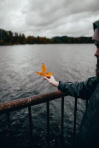 Male survivors of childhood sexual abuse holding a leaf on the lakeside