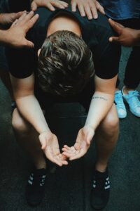 A man sitting depressed while his friends supporting him indicating colorado's suicide rate