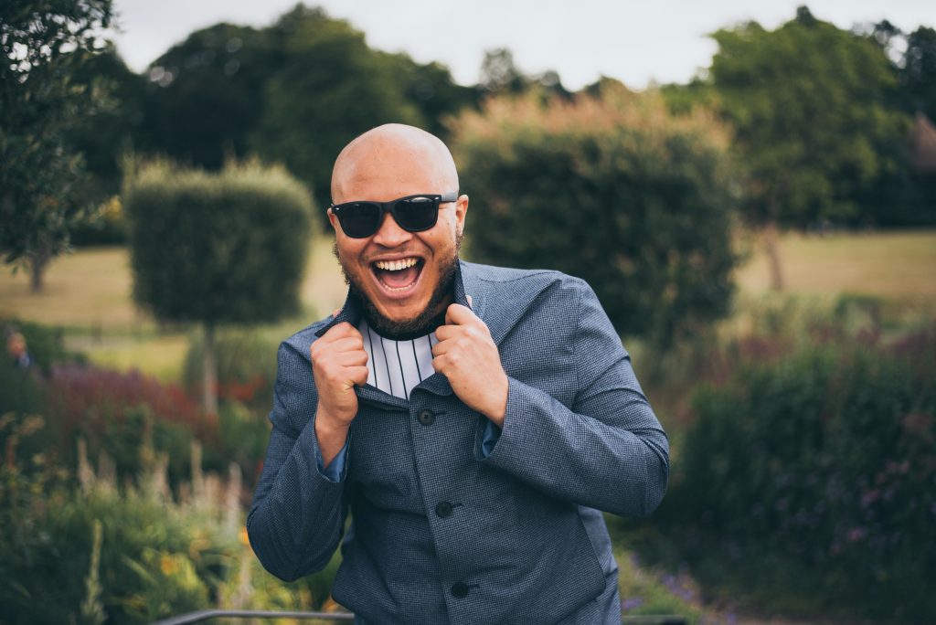 A happy man posing with a beautiful view of nature, reflecting relaxation and peace in therapy.