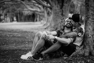 A happy gay couple sitting together emphasizing LGBTQ+ therapy benefits.