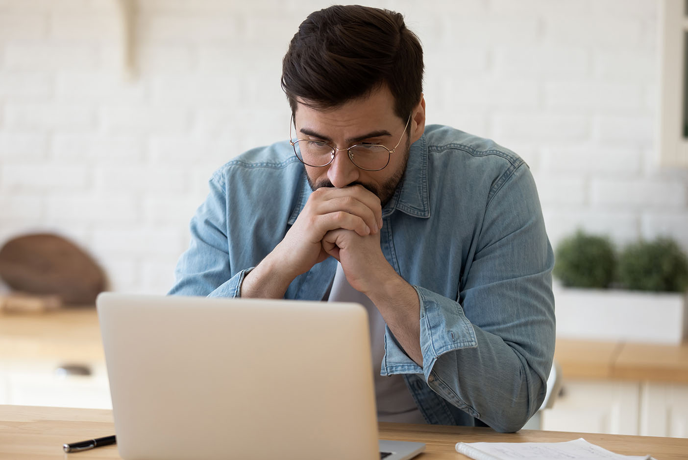 Man sitting depressed in front of laptop signifying therapy needs.