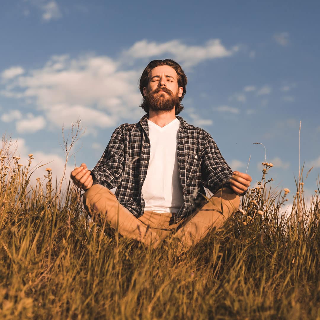 Man meditating outdoors for mindfulness practice.