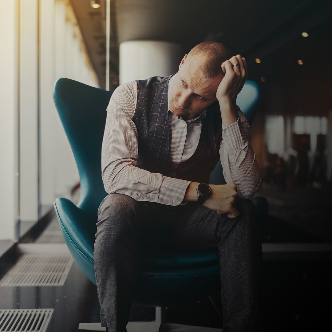 A man sitting with stress evident on his face