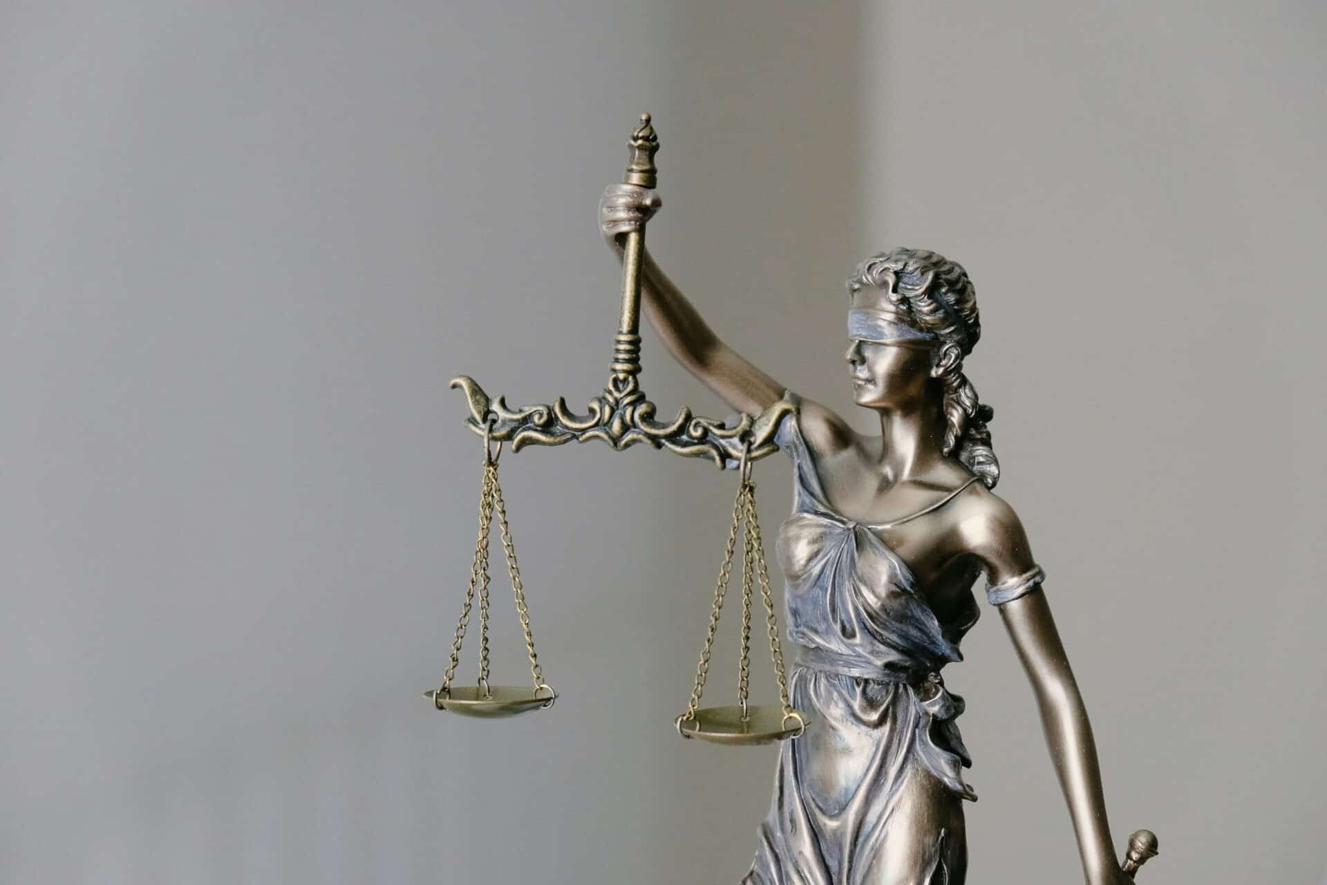 Statue of Lady Justice with scales symbolizes fairness in law.