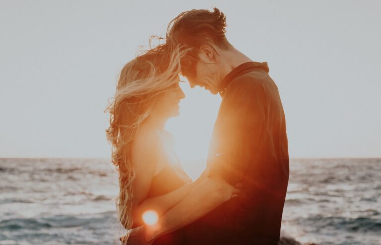 A happy couple basks in the sunset rays on the beach