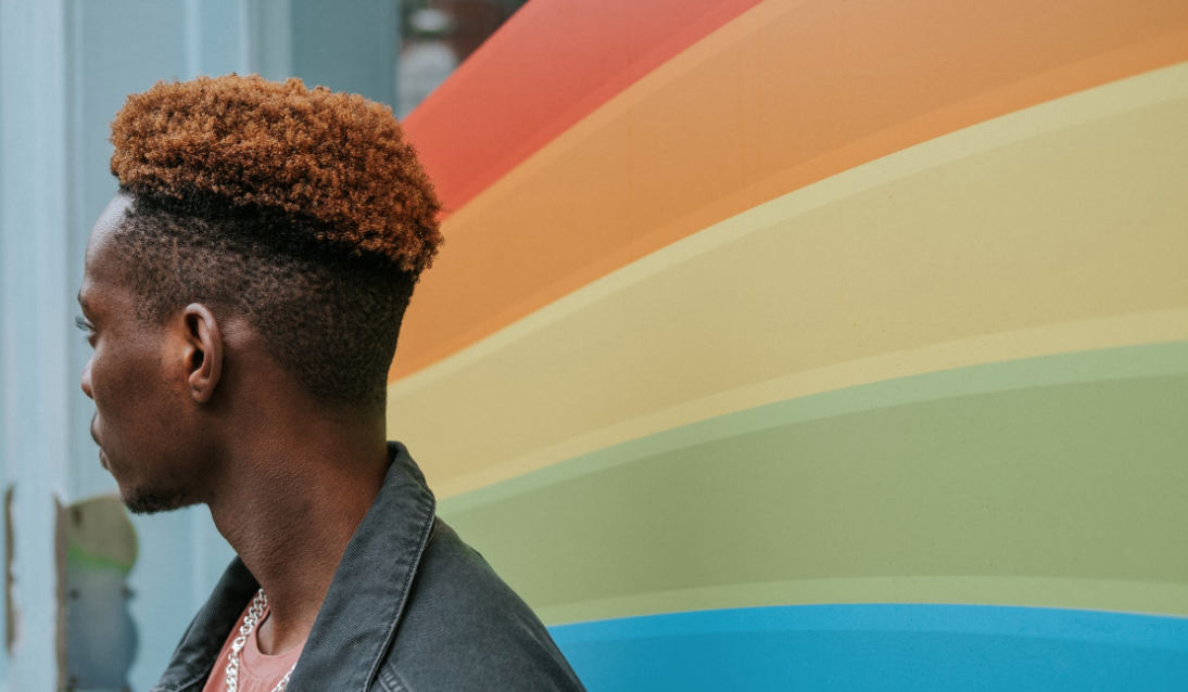 Man with LGBTQ+ flag signifying Denver Men's Therapy LGBTQ+ affirming services.