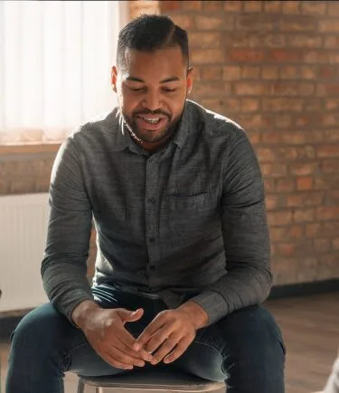 A man smiling after attending the addiction therapy denver