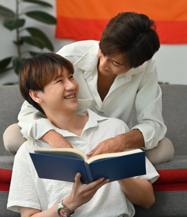 Two young men share a moment of companionship on a couch, embodying the support found in GBTQ+ counseling.