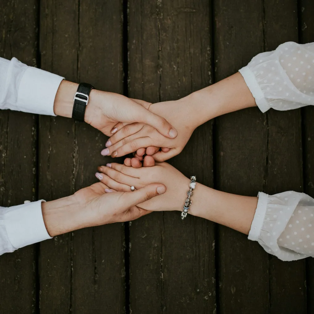 A person’s hands gently holding another’s, symbolizing support in grief counseling in Colorado.