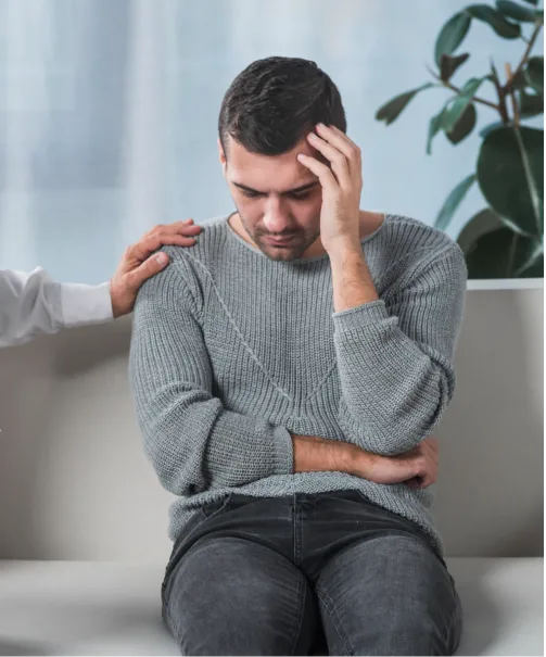 A man sitting in contemplation, seeking support through men's group therapy in Denver.