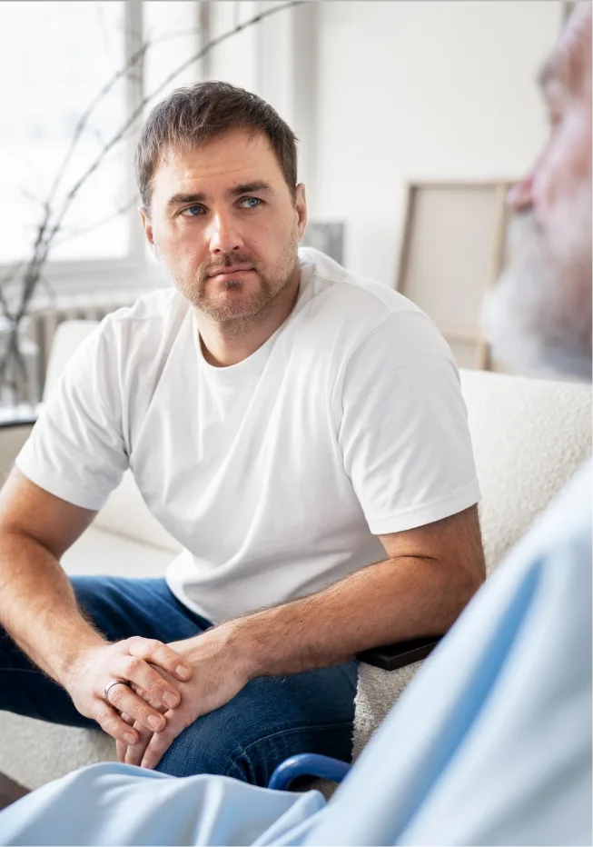 A man looking expectantly at trauma therapist distressed by PTSD symptoms.