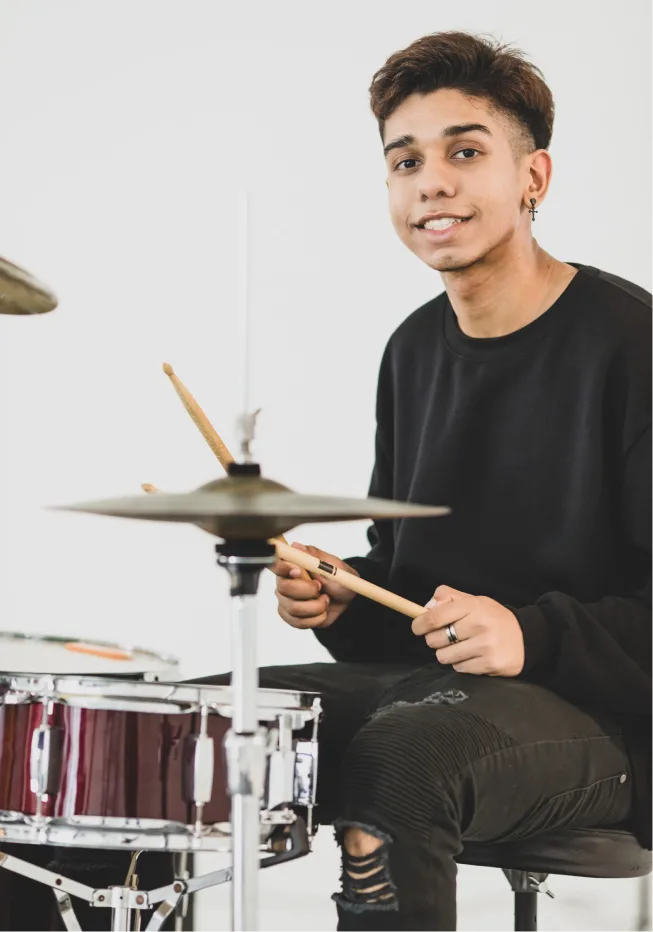 Young man playing drums, feeling empowered after a counseling session in Denver, CO