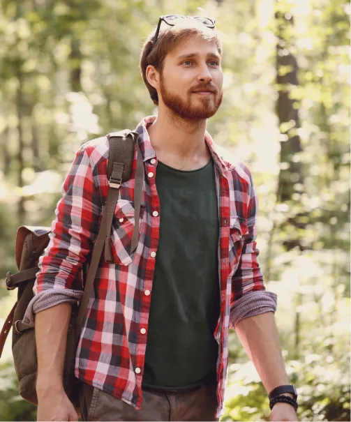 Man trekking through a forest, contemplating the benefits of mushroom therapy in Denver.