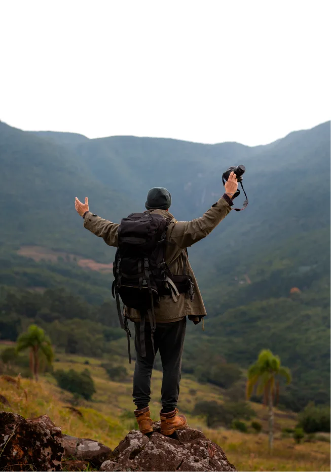 man on cliff enjoying nature with open arms showcasing positive impact of psilocybin therapy denver