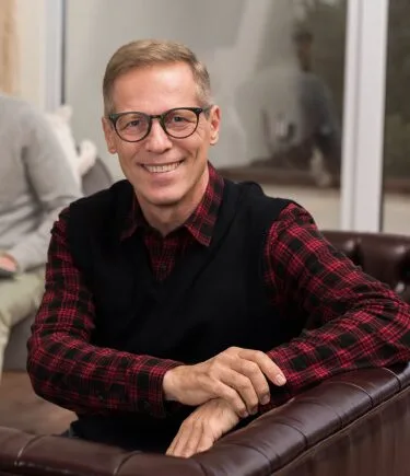 Older man smiling at the camera, highlighting the positive effects of psychedelic therapy in Denver.