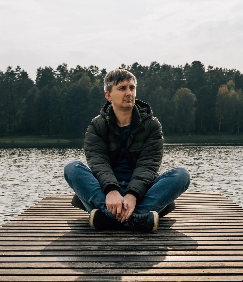 Man finding peace and tranquility near a lake after religious trauma therapy in Denver