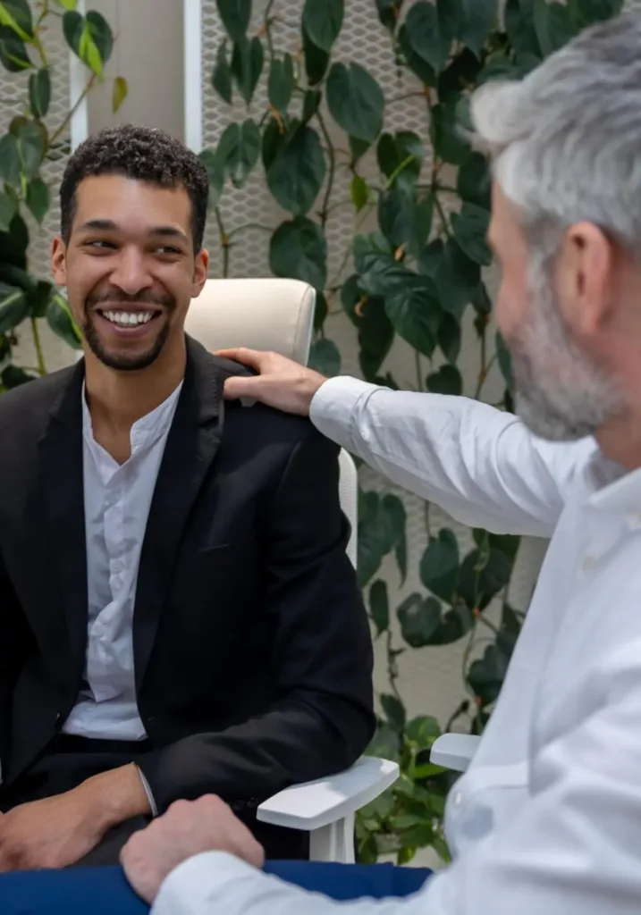 man joyfully discussing his progress and insights with his therapist after a self-love therapy session in Denver