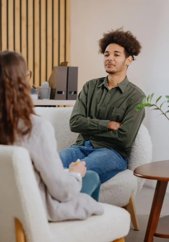 Man engages in anger management counseling session, discussing concerns with an attentive therapist