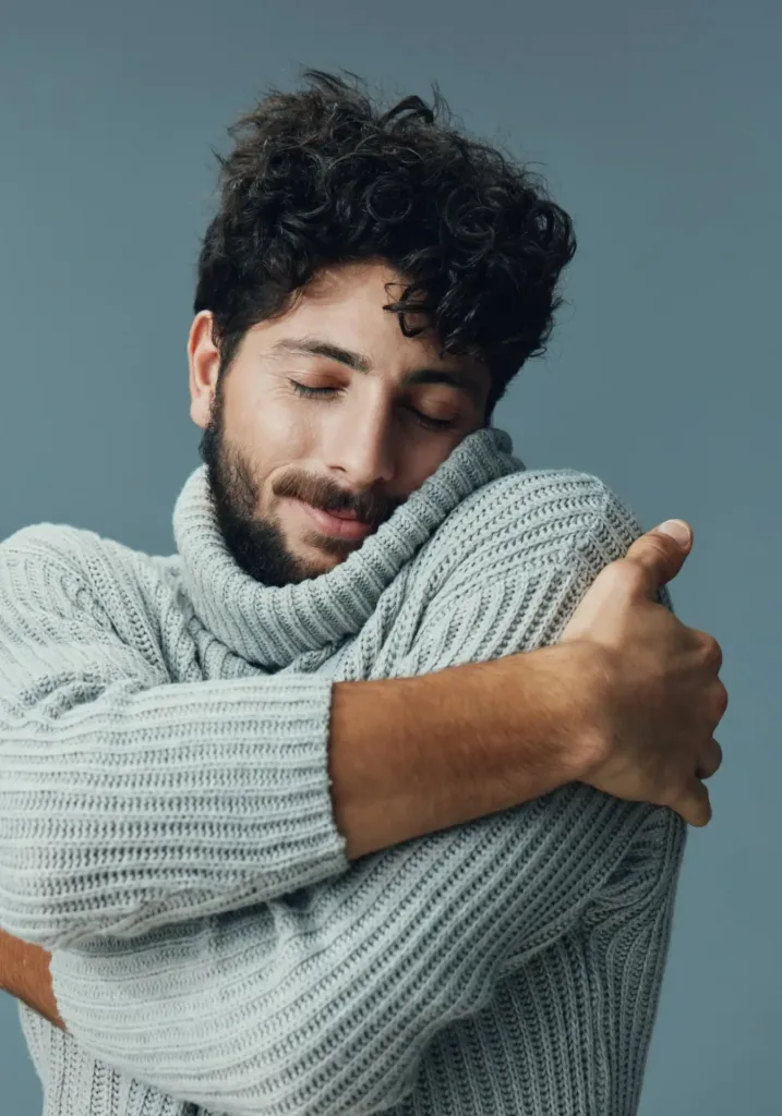 Man hugging himself symbolizing self-acceptance and appreciation after self-love therapy in Denver.