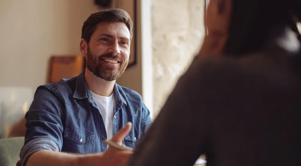 Man engaged in a thoughtful discussion about his goals during a self-esteem counseling session in Denver