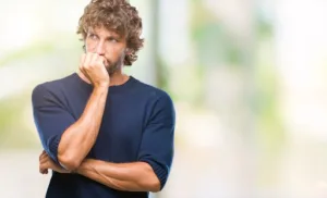 Anxious young man biting nails, visually representing the difference between shame and embarrassment in daily life