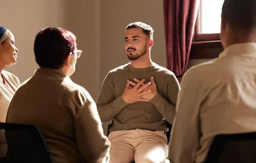 Man opening up in group therapy session, finding support for shame and self-worth issues with Denver Men’s Therapy