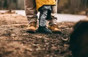 Close up of shoes of a man and his kid exploring nature together